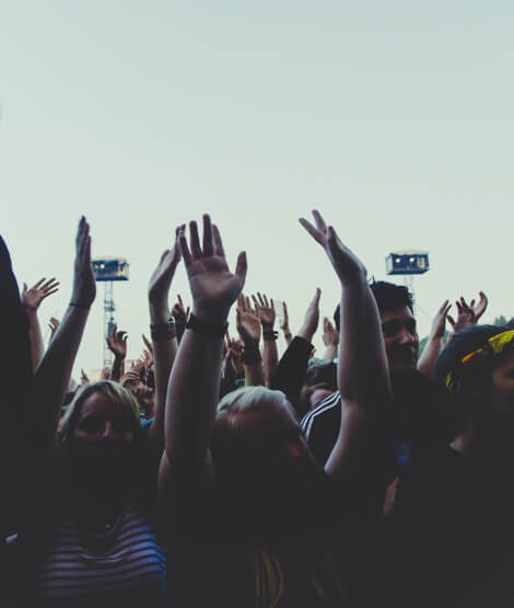 Crowd filming and raising hands